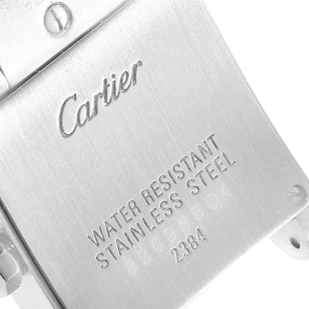 The image shows the back of a Tank Francaise model watch by Cartier, highlighting its stainless steel case with branding and specifications.