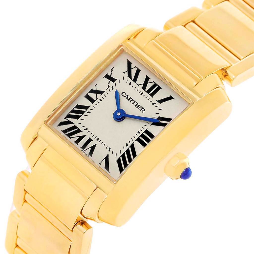 The image shows a Cartier Tank Francaise W50002N2 Women's Yellow Gold Silver Dial W50002N2 Women's Yellow Gold Silver Dial watch at a tilted angle, highlighting the gold case, bracelet, and the dial with Roman numerals.