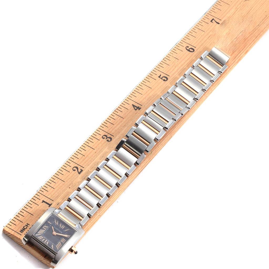 This image shows the Cartier Tank Francaise W5010001 Women's Steel and Gold (two tone) Black Dial W5010001 Women's Steel and Gold (two tone) Black Dial watch laid flat against a ruler, displaying the entire watch and its metal bracelet.