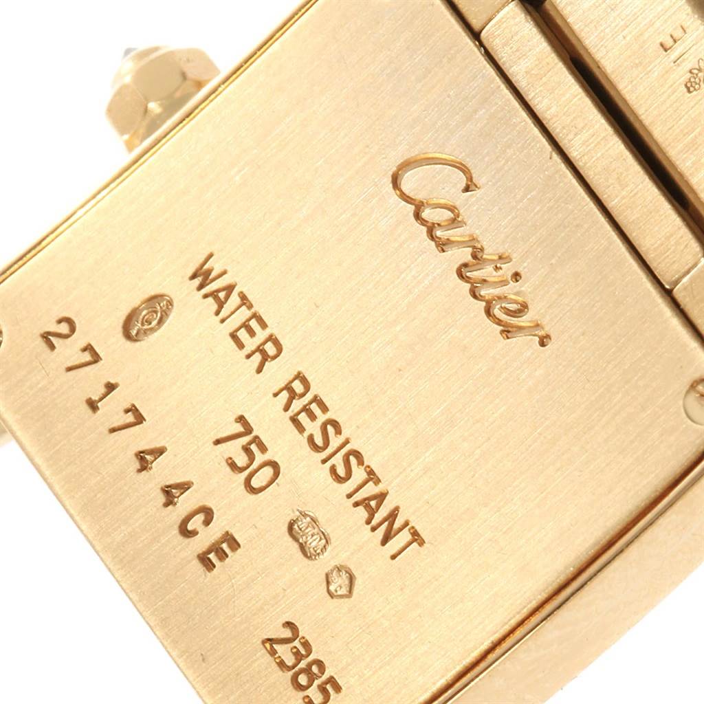 This image shows the back of the Cartier Tank Francaise WE1001R8 Women's Yellow Gold Silver Dial WE1001R8 Women's Yellow Gold Silver Dial watch with brand markings and specifications etched on the metal surface.