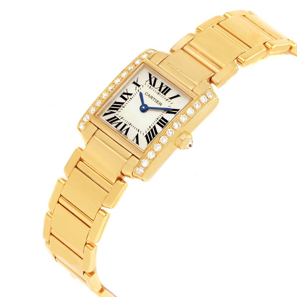This image shows a Cartier Tank Française watch with a gold bracelet, jeweled bezel, and a clear view of the face displaying Roman numerals.