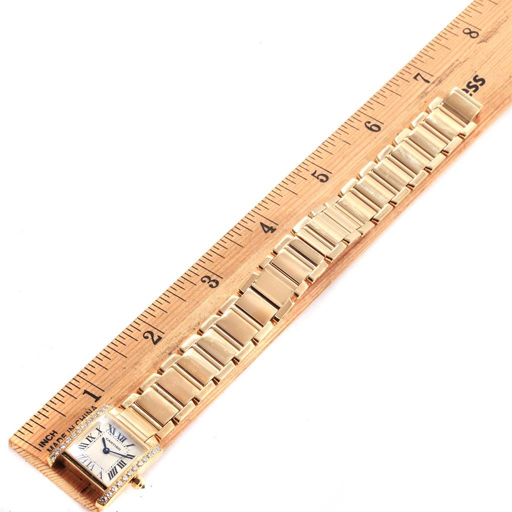 This image shows the Tank Francaise watch by Cartier laid flat next to a ruler, displaying the length of the watch's band.