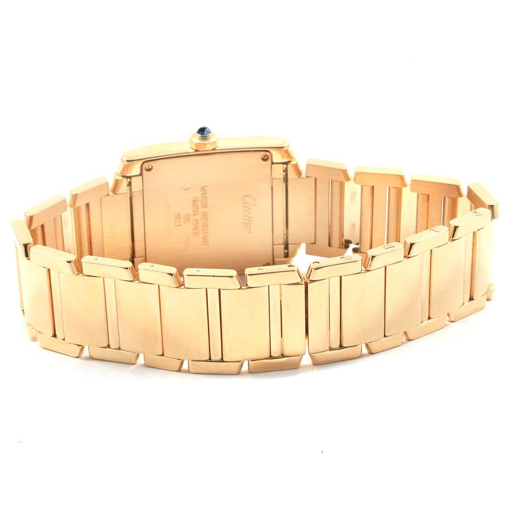 The image shows the back and bracelet of a Cartier Tank Française watch, revealing its gold links and case back.