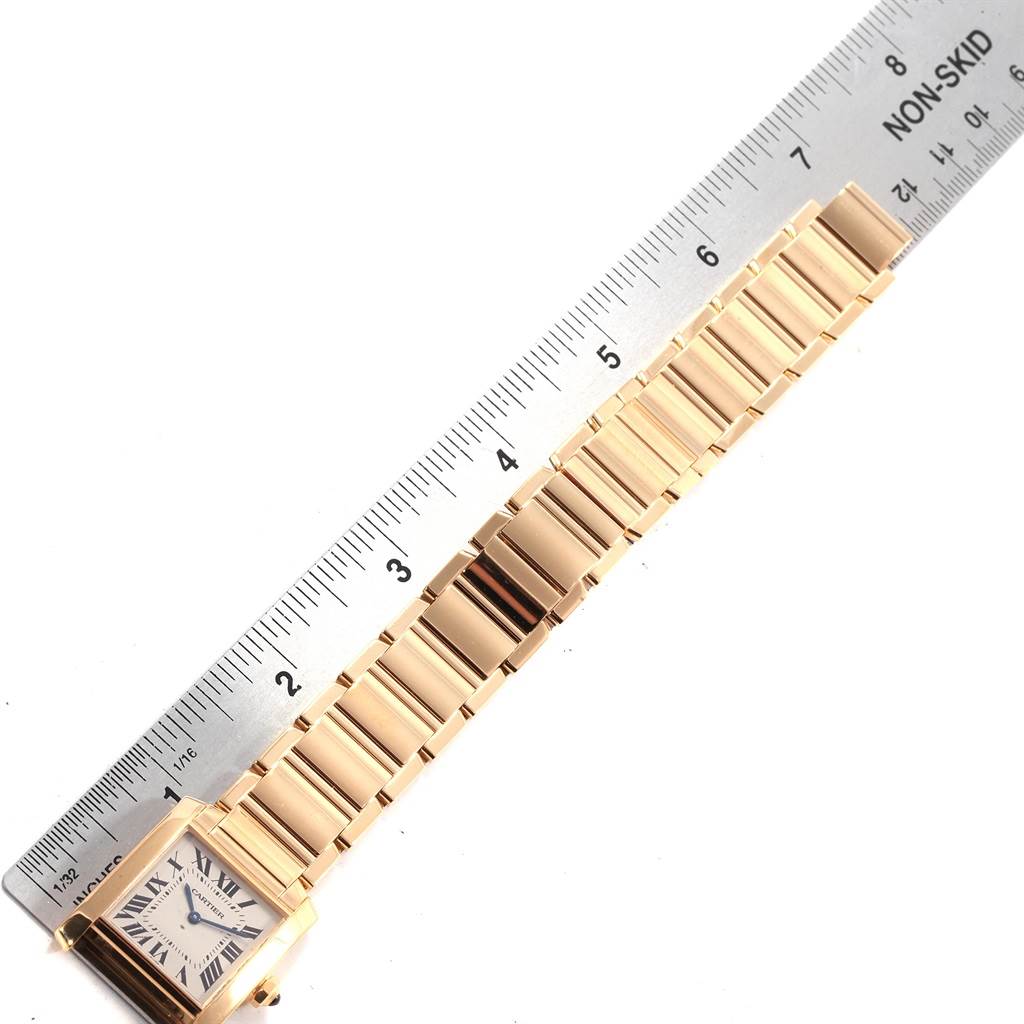 The image shows a Cartier Tank Francaise W50003N2 Women's Yellow Gold Silver Dial W50003N2 Women's Yellow Gold Silver Dial watch laid flat, displaying its bracelet and a portion of the dial with a ruler for measurement.