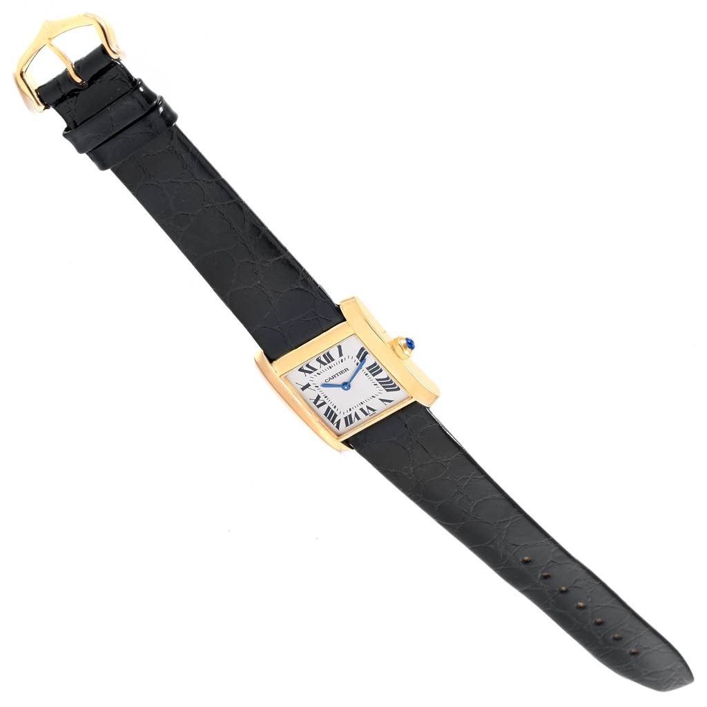 The Cartier Tank Francaise W50003N2 Women's Yellow Gold Silver Dial W50003N2 Women's Yellow Gold Silver Dial watch is displayed at an oblique angle, showing its face, leather strap, and buckle.