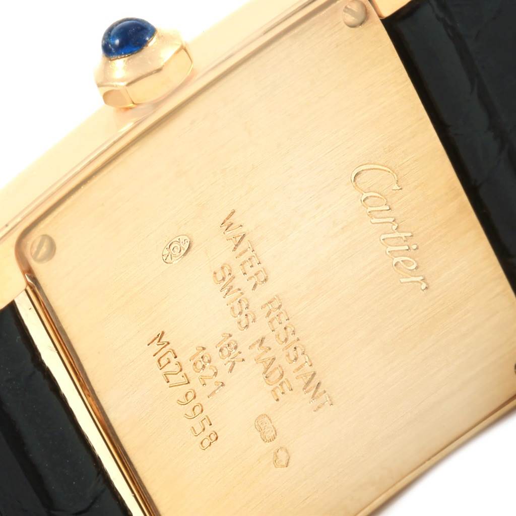 The image shows the back case and crown of a Cartier Tank Francaise W50003N2 Women's Yellow Gold Silver Dial W50003N2 Women's Yellow Gold Silver Dial watch, highlighting its engravings and detailing.