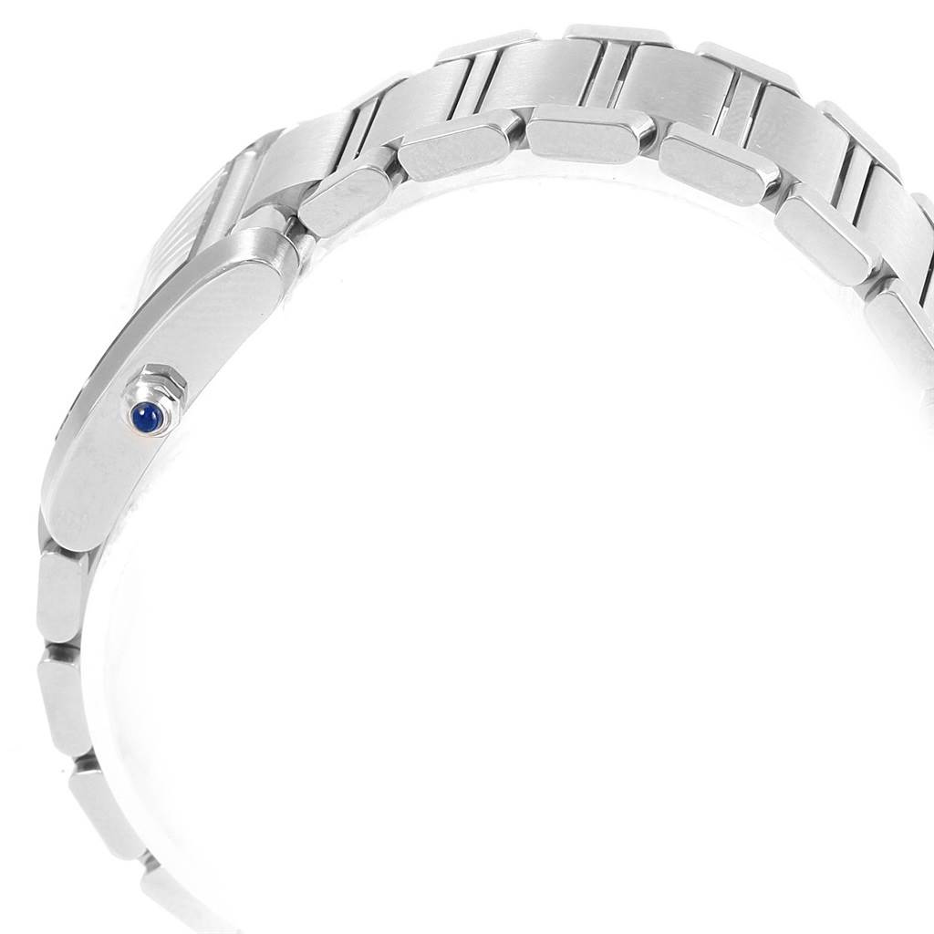 This image shows a side angle of the Tank Francaise model bracelet by Cartier, focusing on the links and crown with a blue gem.