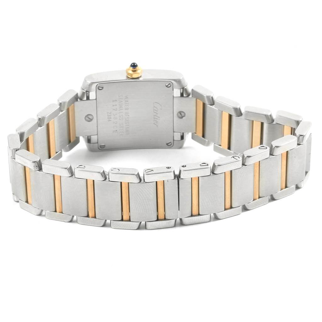 The image shows the back of a Cartier Tank Française watch with its stainless steel and gold two-tone bracelet.