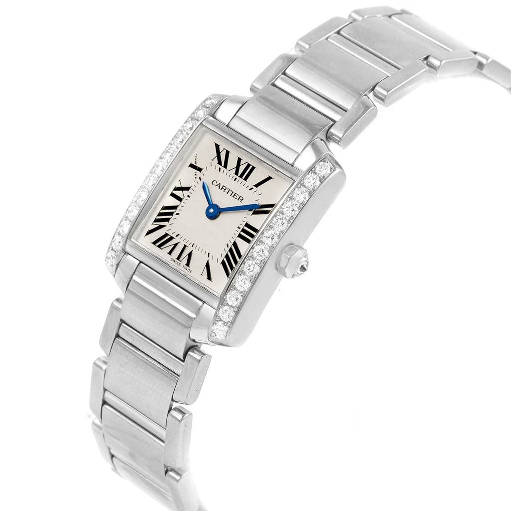 The image shows a Tank Francaise model watch by Cartier, angled slightly to display the face, blue hands, Roman numerals, and stainless steel bracelet.