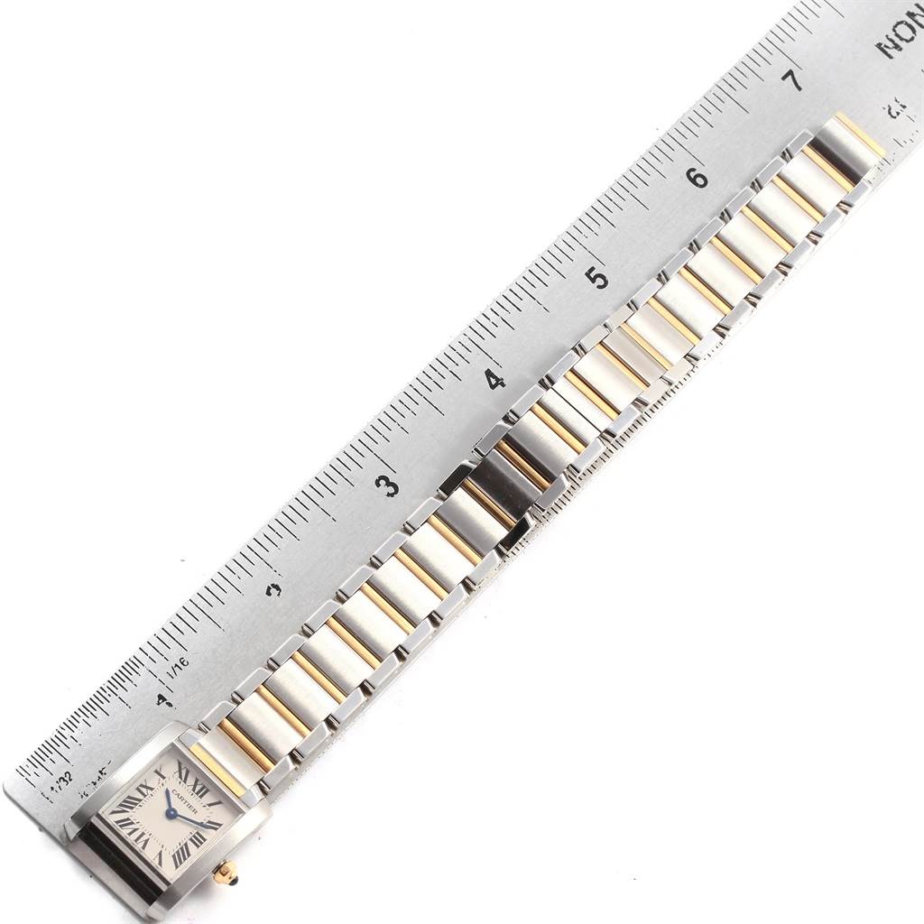 This image shows a Tank Francaise model by Cartier with a focus on the watch face and metal bracelet, alongside a ruler for measurement.