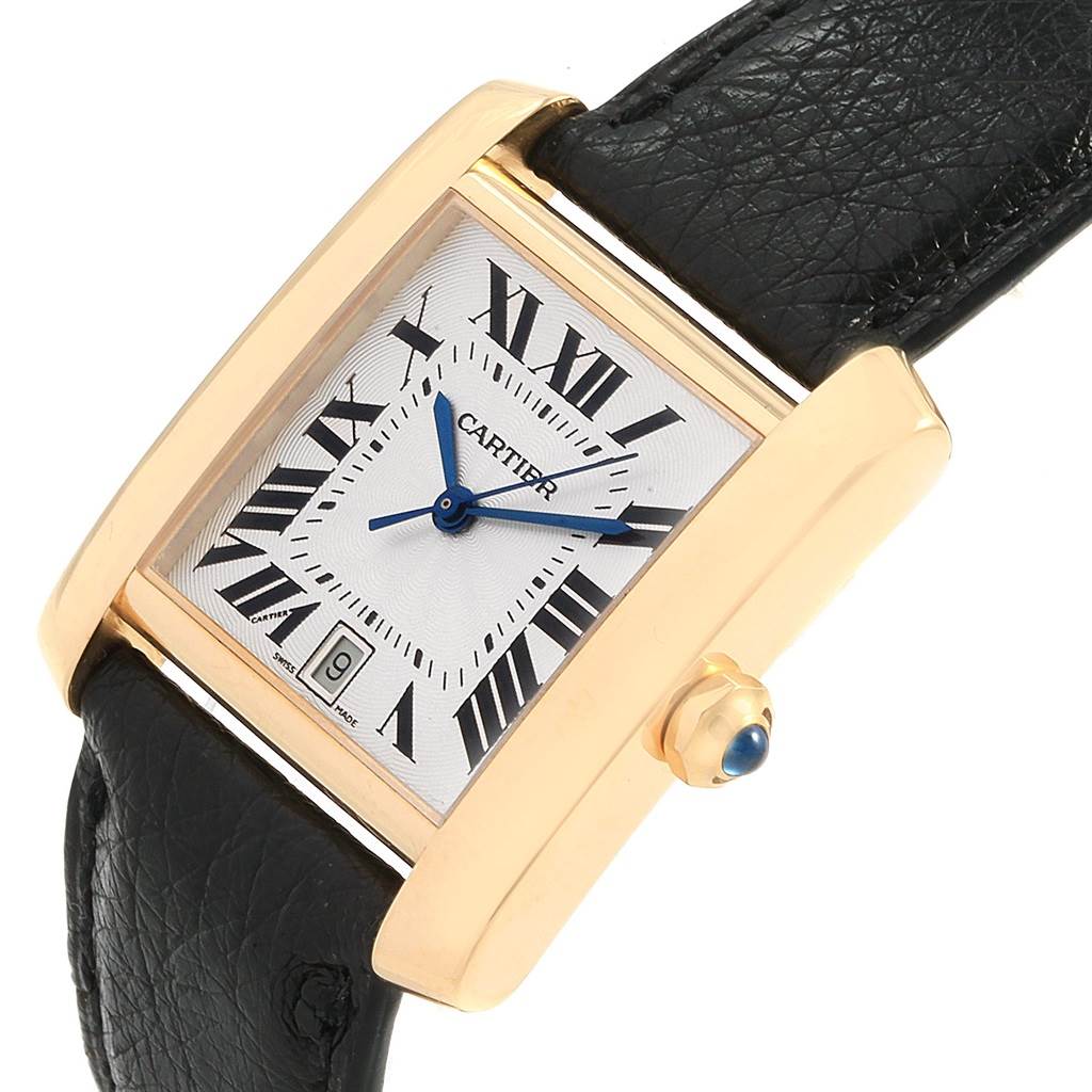 The Cartier Tank Francaise W5000156 Yellow Gold Silver Dial W5000156 Yellow Gold Silver Dial watch is shown at an angled view, displaying its face, crown, and part of the leather strap.
