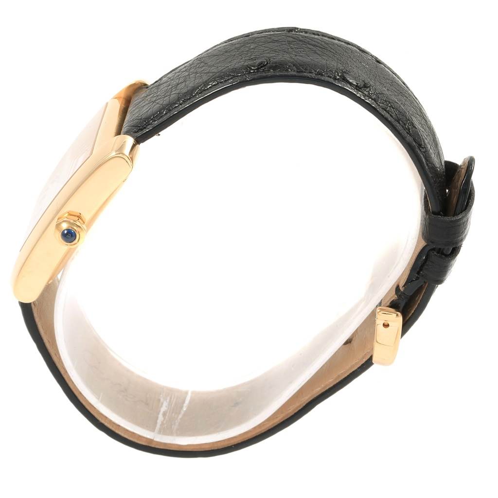 The image shows a side view of the Cartier Tank Francaise W5000156 Yellow Gold Silver Dial W5000156 Yellow Gold Silver Dial watch, highlighting its black leather strap and gold crown.