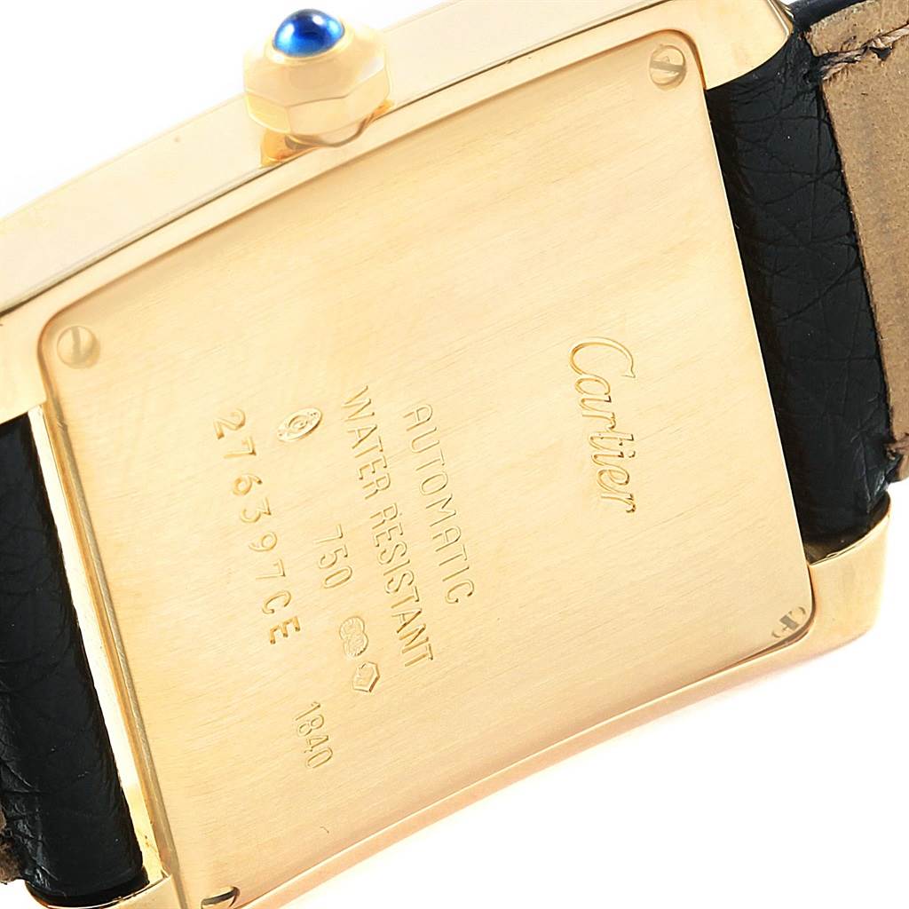 The image shows the back case of a Cartier Tank Francaise W5000156 Yellow Gold Silver Dial W5000156 Yellow Gold Silver Dial watch with its inscriptions and a leather strap.