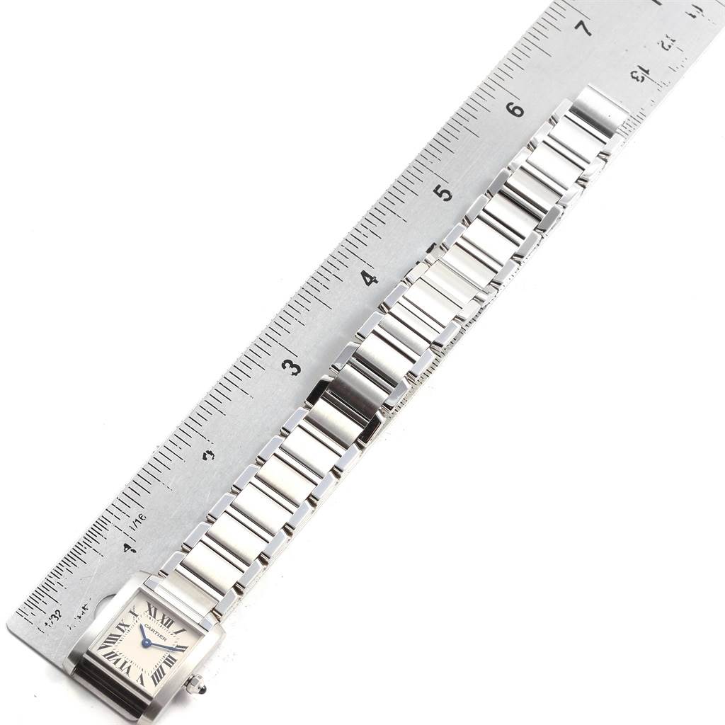 The image shows the Cartier Tank Française watch face and bracelet laid flat next to a ruler for scale.