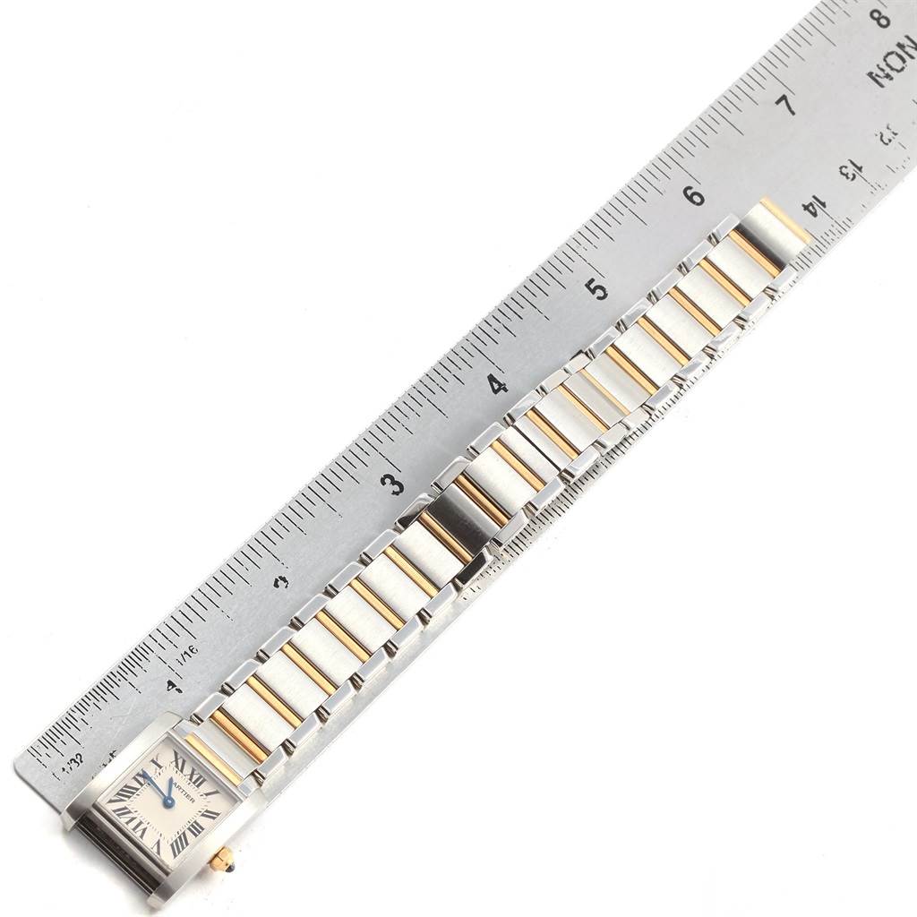 This image shows a Cartier Tank Francaise W51007Q4 Women's Steel and Gold (two tone) Silver Dial W51007Q4 Women's Steel and Gold (two tone) Silver Dial watch, focused on the bracelet and face, lying adjacent to a ruler.