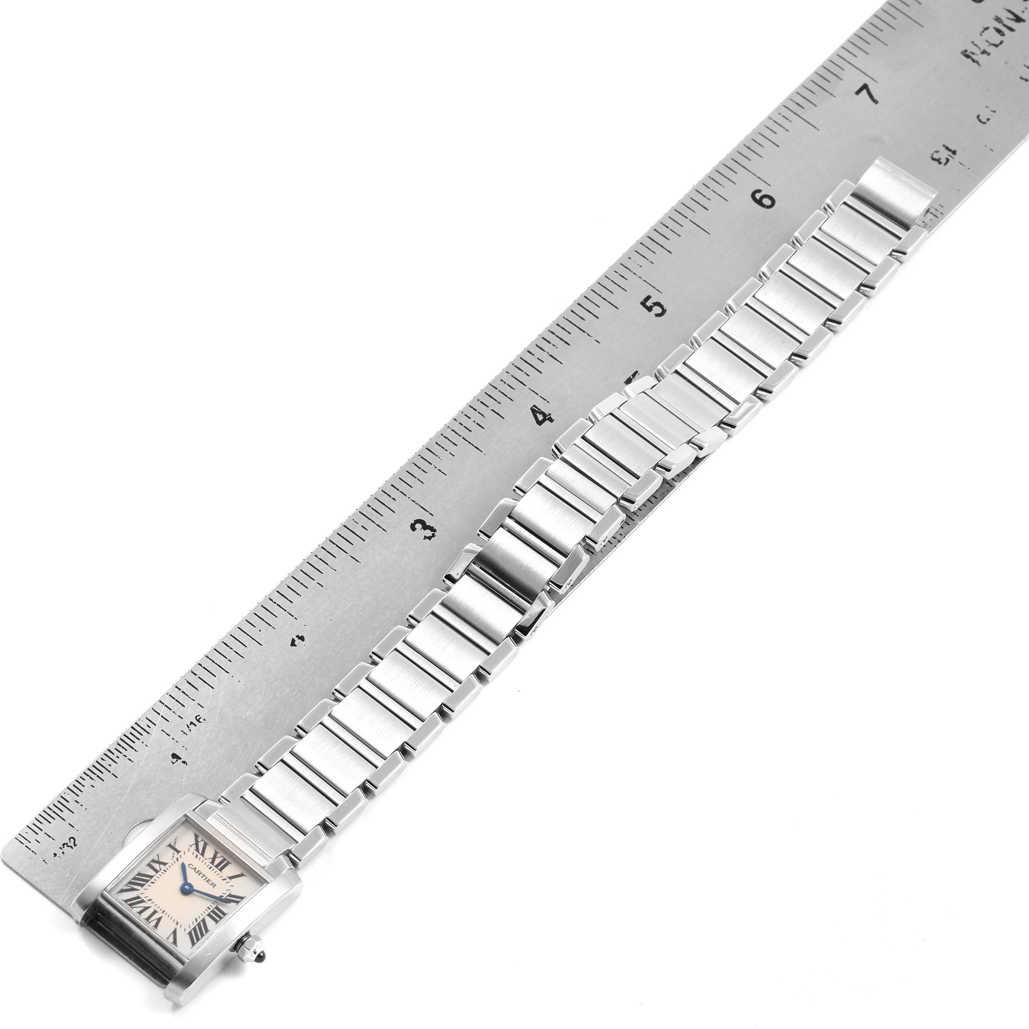 The image shows a top-down view of a Cartier Tank Française watch with a ruler measuring its bracelet length.