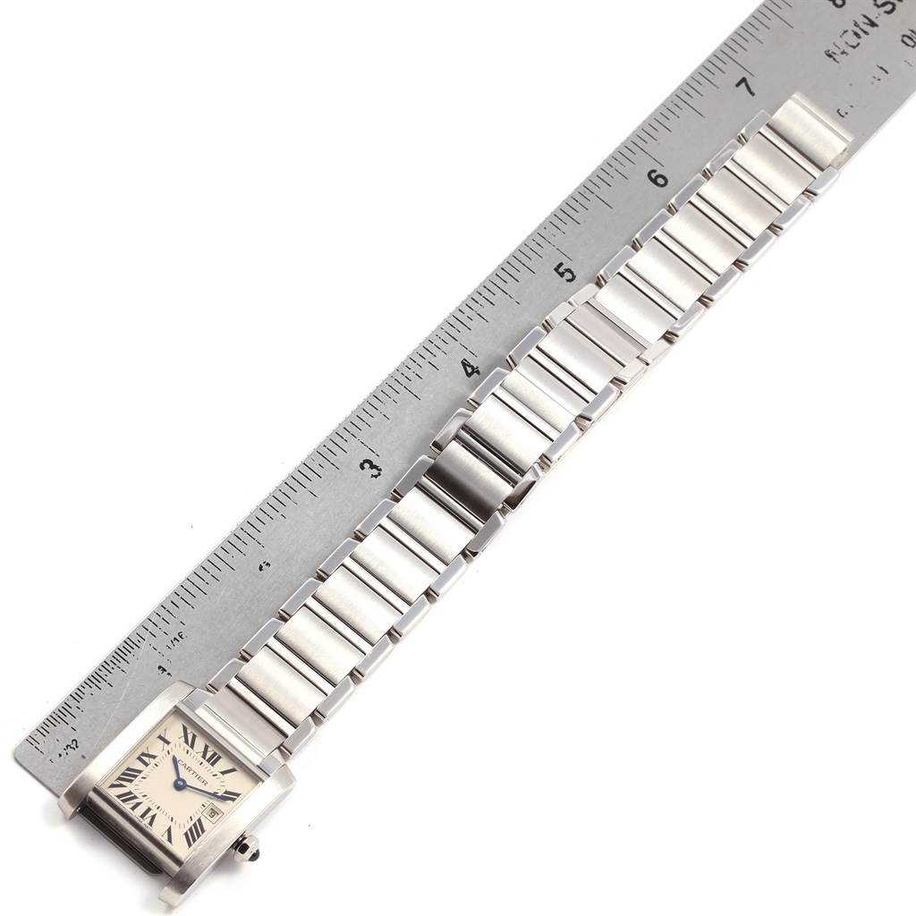 This image shows the full length of a Tank Francaise watch by Cartier, including the face and metal bracelet, aligned with a ruler.