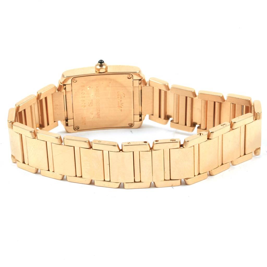 The Cartier Tank Française watch is shown from the back, highlighting its gold bracelet and case back.