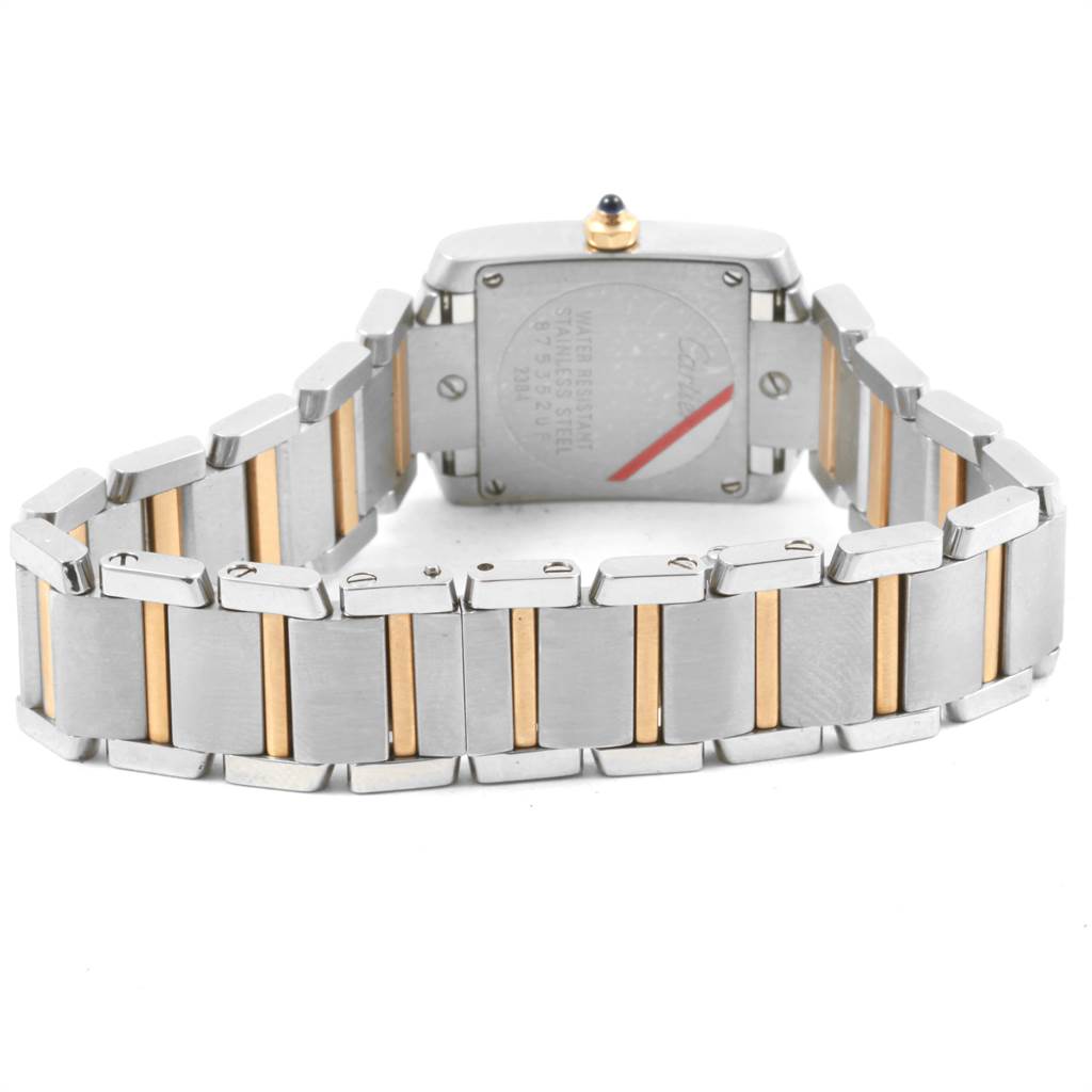 The image shows the back of a Cartier Tank Française watch, highlighting the stainless steel and gold bracelet.