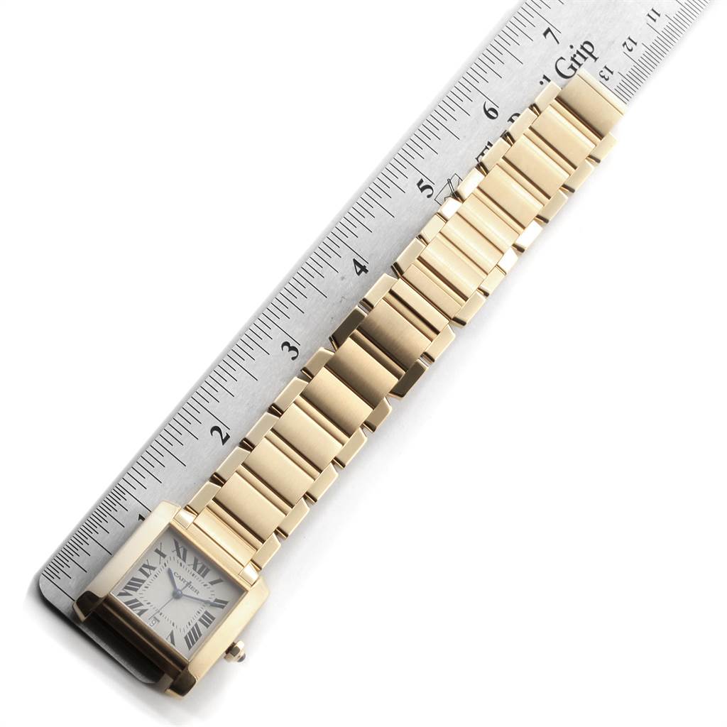 The Tank Francaise by Cartier is shown from a top-down angle, displaying the face, bracelet, and a ruler for scale.