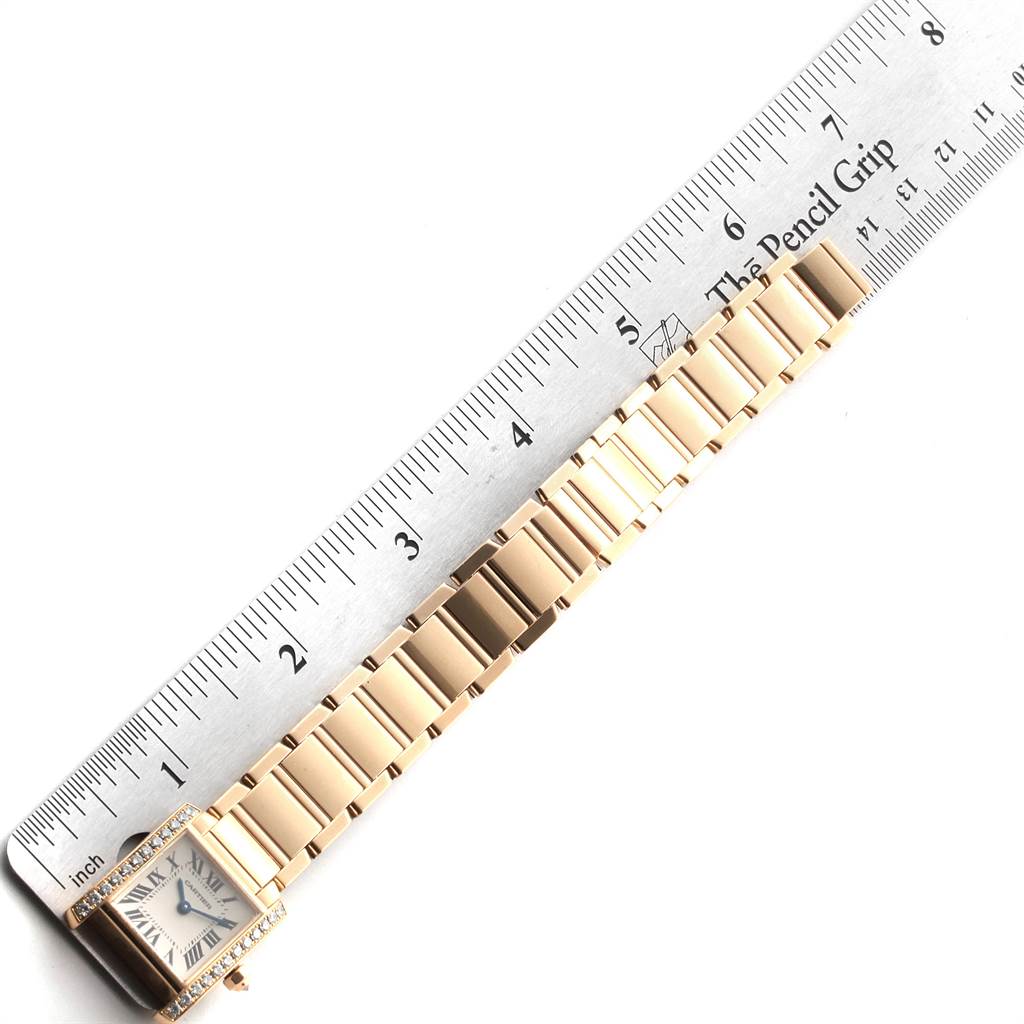 This image shows a Cartier Tank Francaise WE1001R8 Women's Yellow Gold Silver Dial WE1001R8 Women's Yellow Gold Silver Dial watch laid flat with a ruler measuring its length.