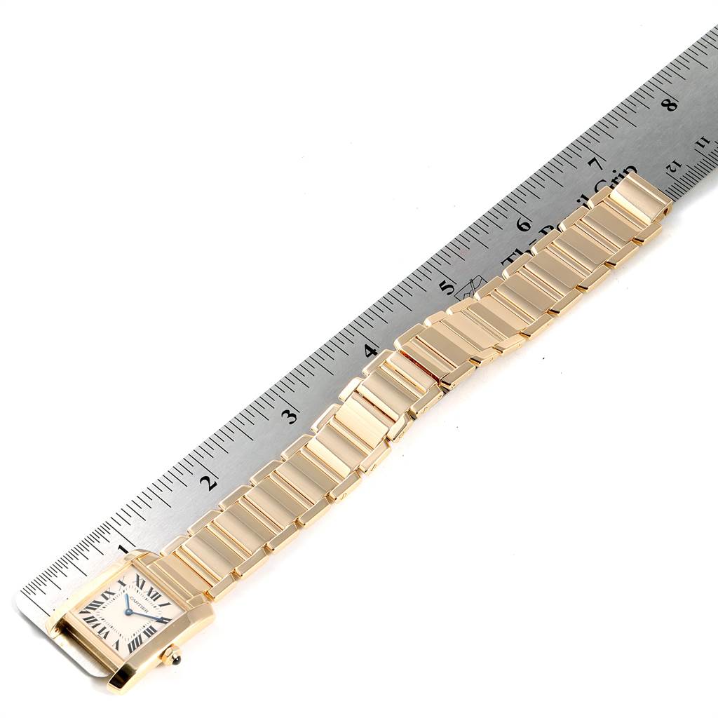 The image shows a Cartier Tank Française watch positioned next to a ruler, displaying the face and bracelet from a top-down angle.