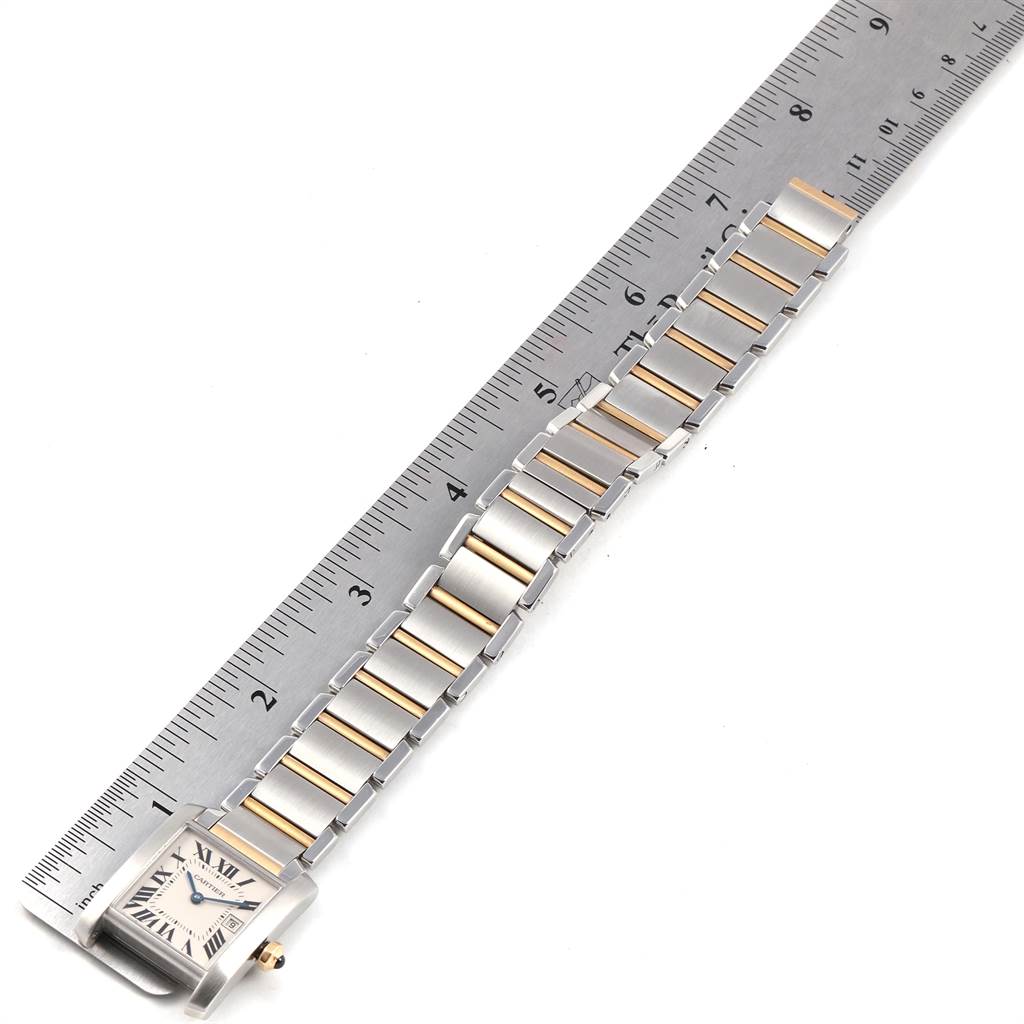 This image shows a Cartier Tank Francaise W51012Q4 Women's Steel and Gold (two tone) Silver Dial W51012Q4 Women's Steel and Gold (two tone) Silver Dial watch laid flat with a ruler for measurement, displaying its face and entire band.