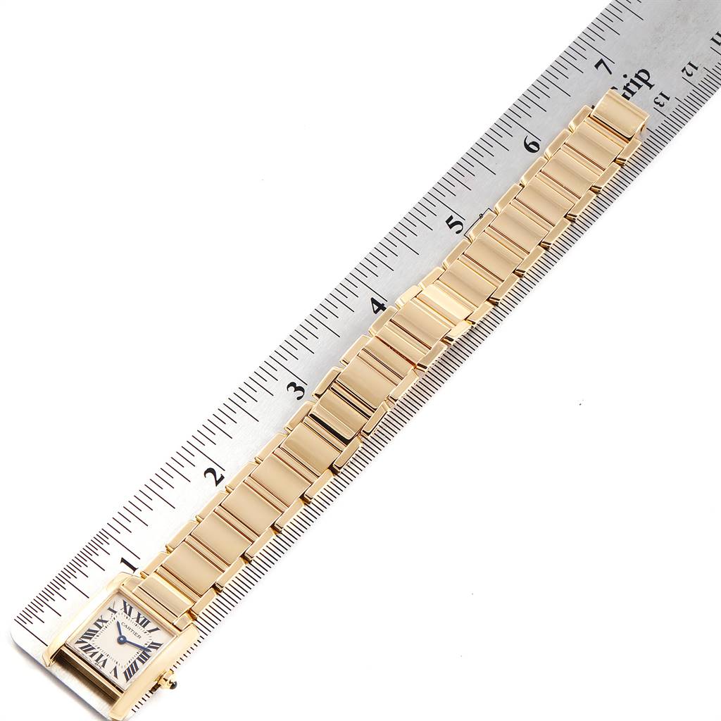 The Tank Francaise model by Cartier is shown from an angled top view, highlighting the watch face and entire bracelet band beside a ruler.