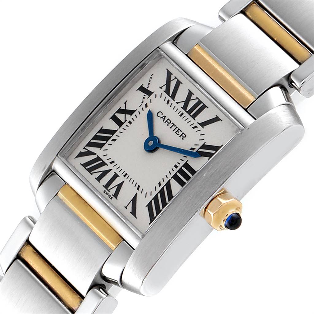 The image shows a Cartier Tank Francaise W51007Q4 Women's Steel and Gold (two tone) Silver Dial W51007Q4 Women's Steel and Gold (two tone) Silver Dial watch at an angle highlighting its face, bracelet, and crown with a blue sapphire cabochon.