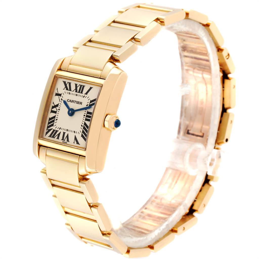 The image shows a Cartier Tank Française watch at a three-quarter angle, highlighting its gold bracelet, Roman numeral dial, and blue cabochon crown.