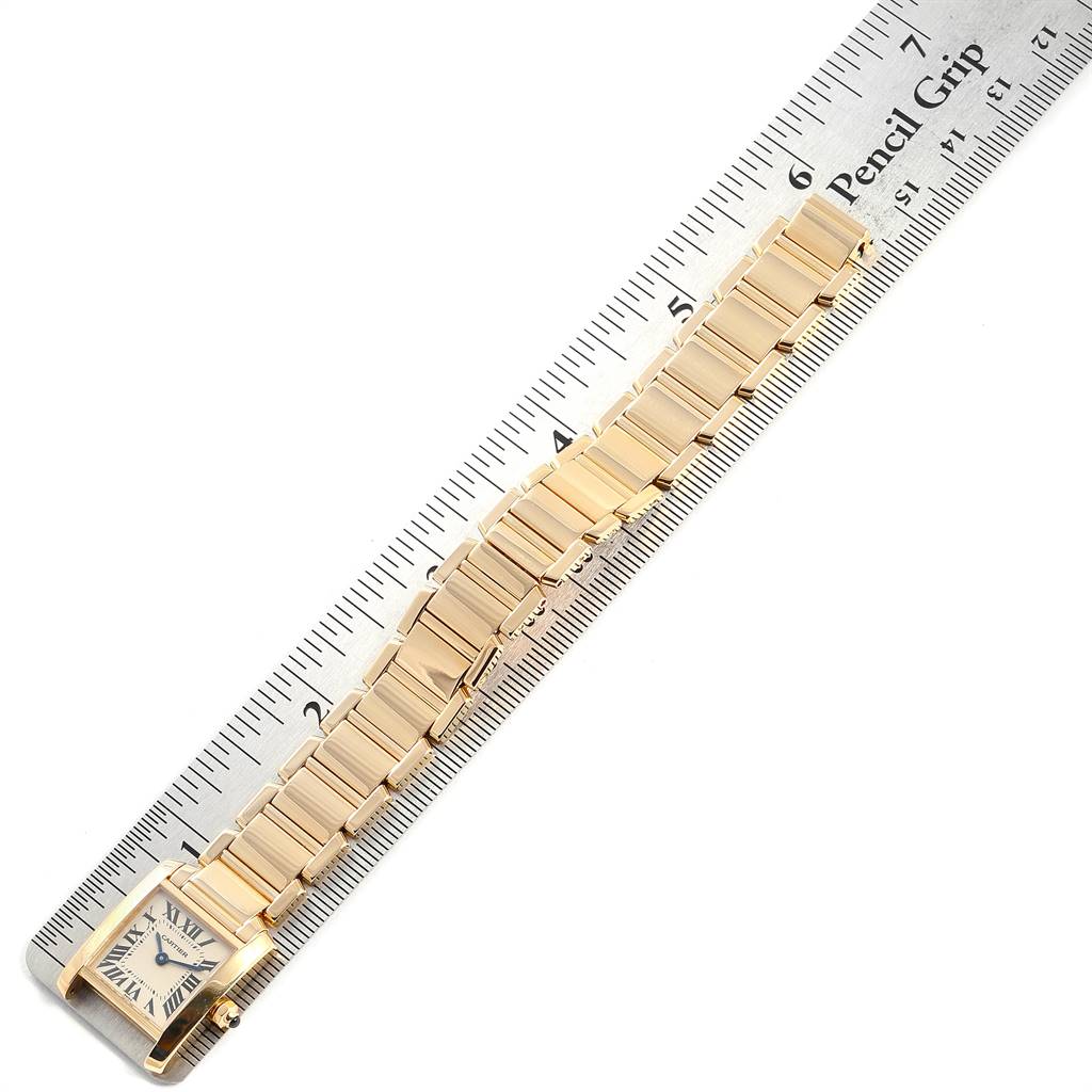 This image shows a gold Cartier Tank Francaise W50002N2 Women's Yellow Gold Silver Dial W50002N2 Women's Yellow Gold Silver Dial watch, placed next to a ruler for size reference.