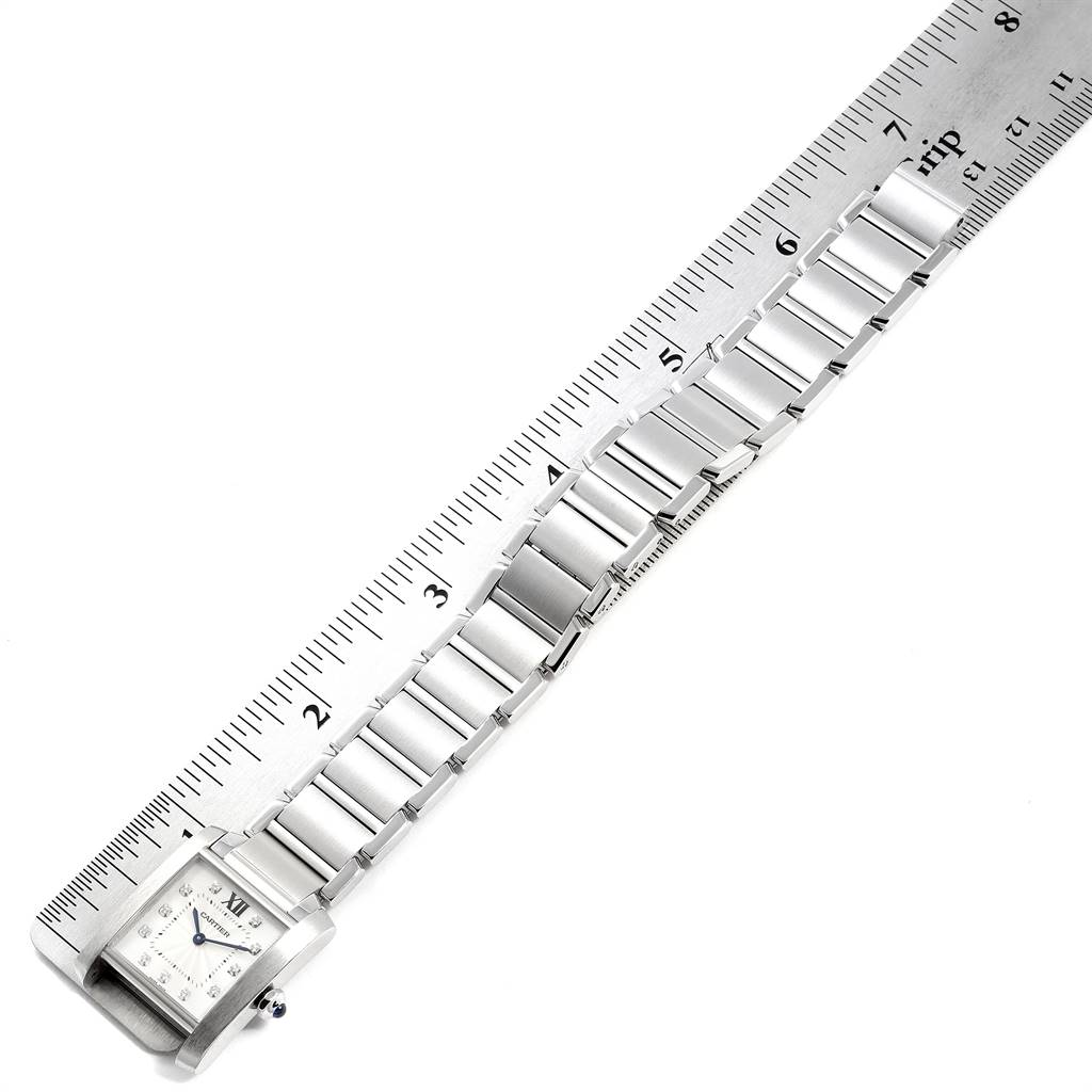 The Cartier Tank Francaise WE110007 Women's Stainless Steel Silver Dial WE110007 Women's Stainless Steel Silver Dial watch is shown at an angle, laying flat next to a ruler, displaying its face and stainless steel bracelet.