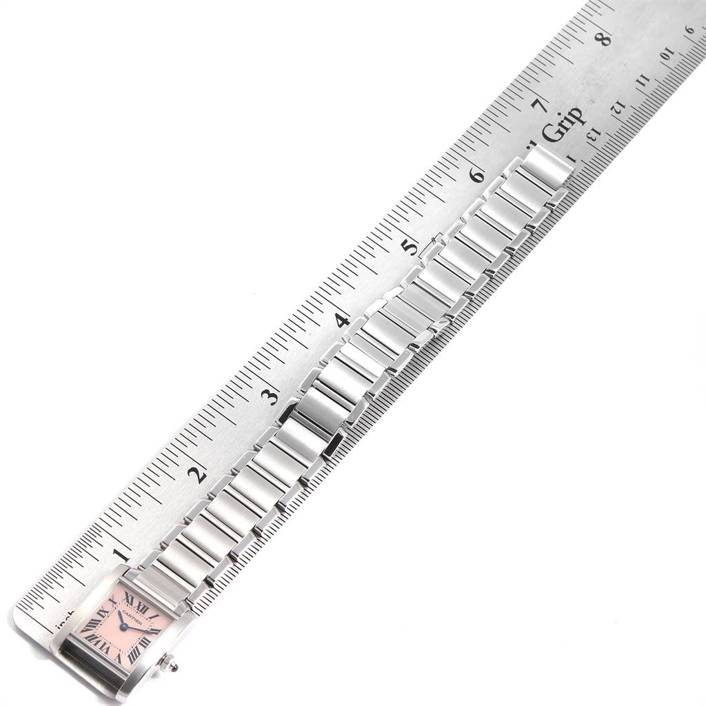 The image shows the stainless steel bracelet and face of a Cartier Tank Francaise W51028Q3 Women's Stainless Steel Mother of Pearl Dial W51028Q3 Women's Stainless Steel Mother of Pearl Dial watch placed parallel to a ruler.