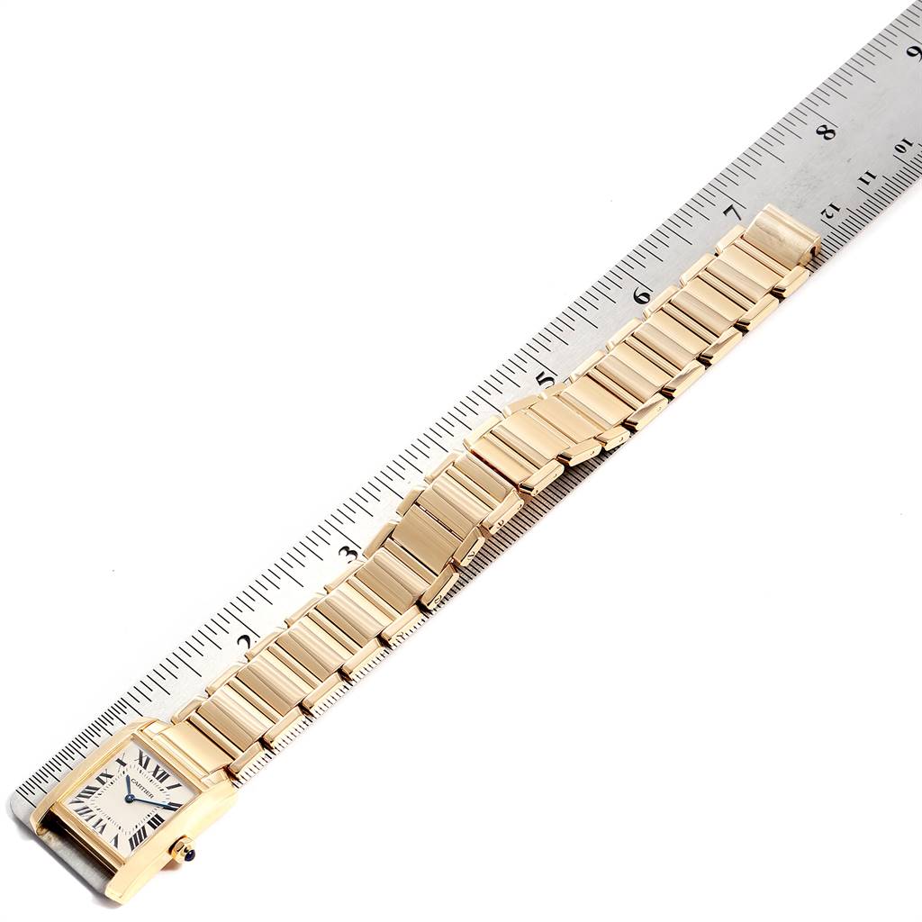 The Cartier Tank Francaise W50003N2 Women's Yellow Gold Silver Dial W50003N2 Women's Yellow Gold Silver Dial watch is shown at an angled perspective, displaying the face and full bracelet alongside a ruler.
