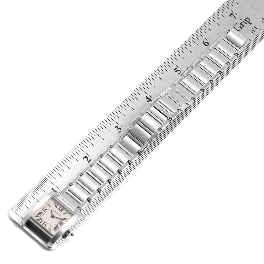 The image shows a Tank Francaise model by Cartier, featuring its bracelet and the watch face, aligned with a ruler for measurement.