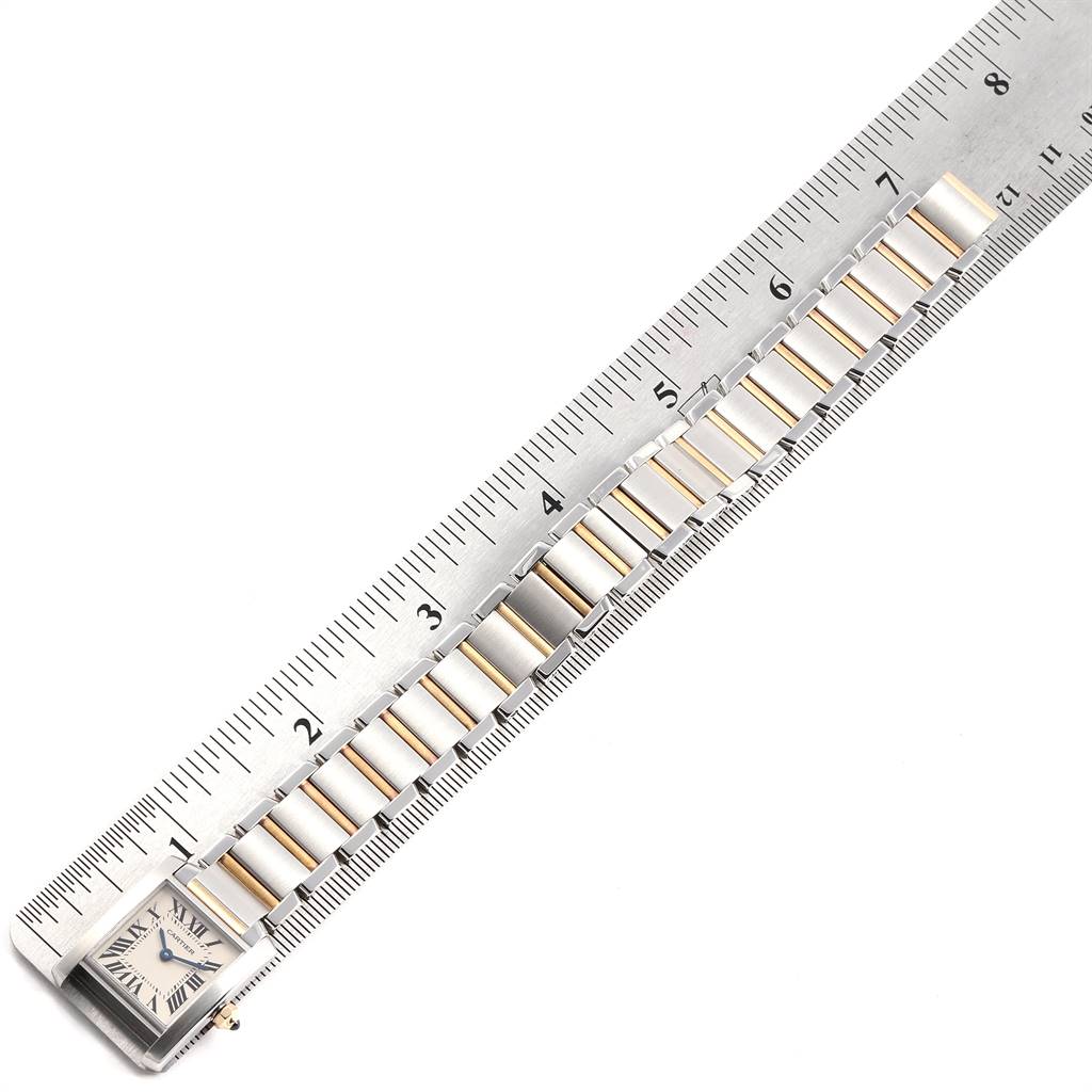 The image shows a horizontal view of the bracelet and watch face of the Cartier Tank Française model next to a ruler.