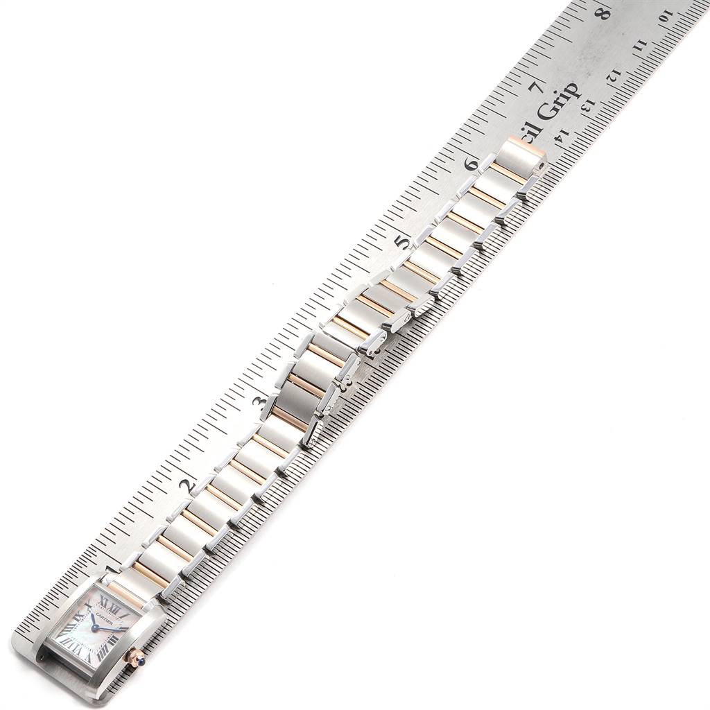 The image shows a Cartier Tank Française watch laid flat with its band extended next to a ruler for measurement.