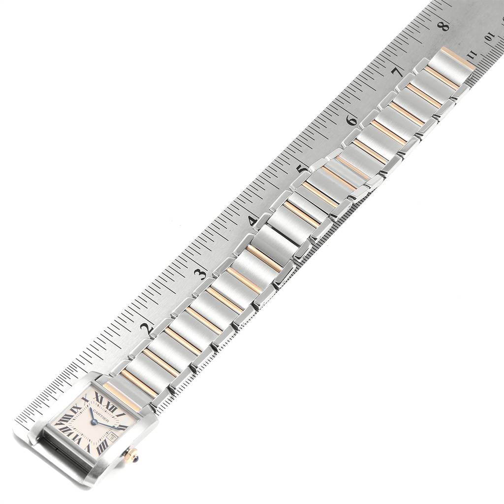 The image shows a top-down view of a Cartier Tank Francaise W51012Q4 Women's Steel and Gold (two tone) Silver Dial W51012Q4 Women's Steel and Gold (two tone) Silver Dial watch with its metal bracelet next to a ruler for measurement.