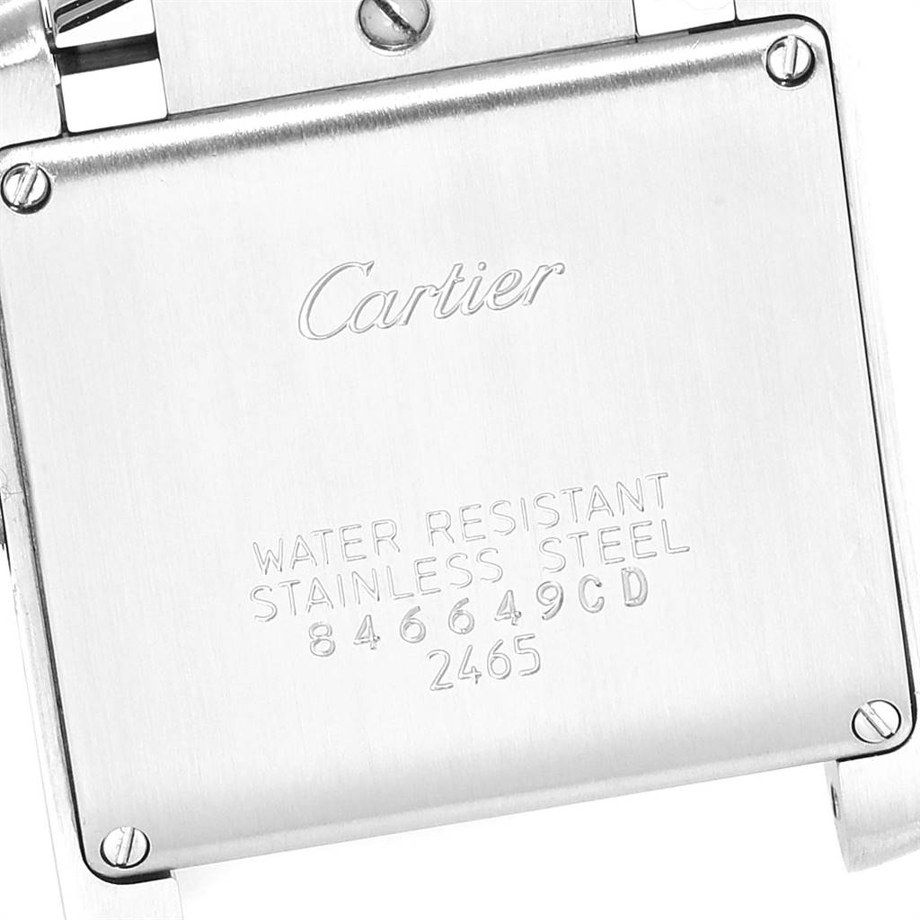 The image shows the back case of a Cartier Tank Française watch with engravings and screws visible.