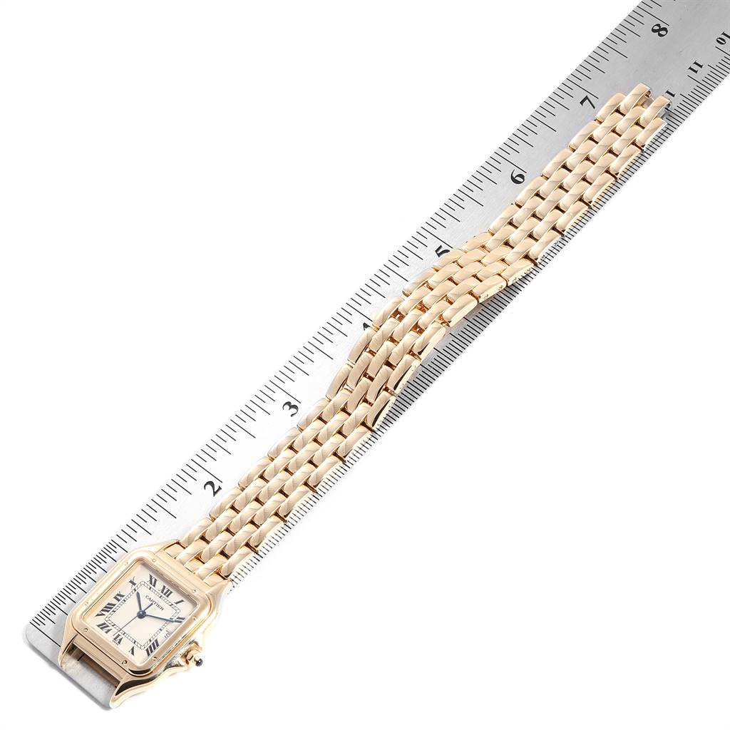 The image shows a gold Cartier Tank Francaise W25014B9 Yellow Gold Silver Dial W25014B9 Yellow Gold Silver Dial watch laid flat alongside a ruler, highlighting the watch face and bracelet.