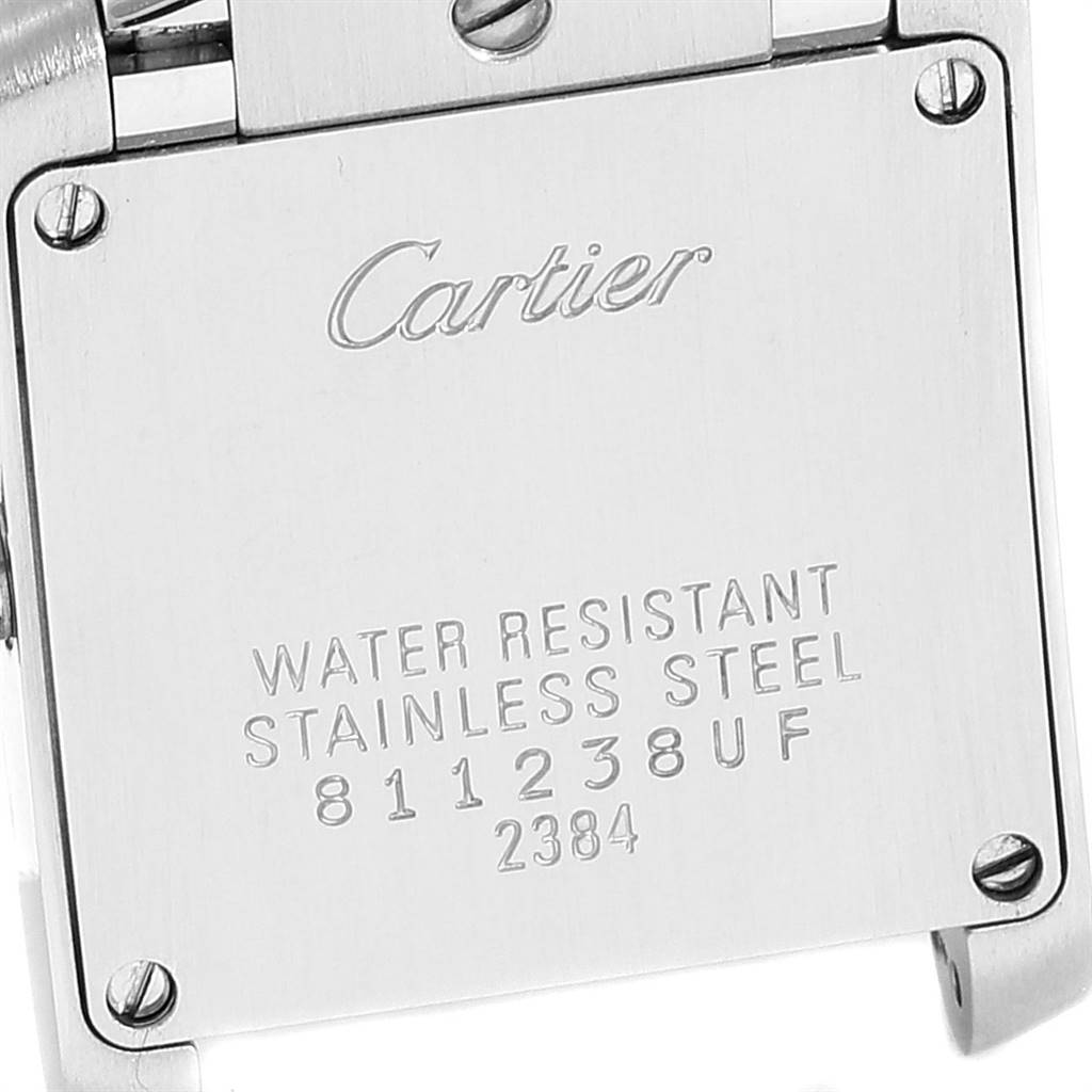 The image shows the case back of a Cartier Tank Française watch at a close-up angle, displaying the brand name and material details.