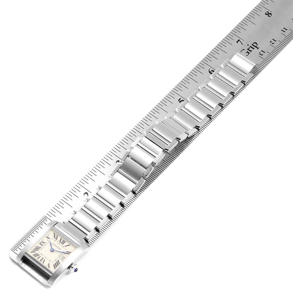 The Cartier Tank Francaise W51011Q3 Women
s Stainless Steel Silver Dial W51011Q3 Women
s Stainless Steel Silver Dial watch is shown from a top view, displaying its face and metal bracelet partially extended along a ruler.