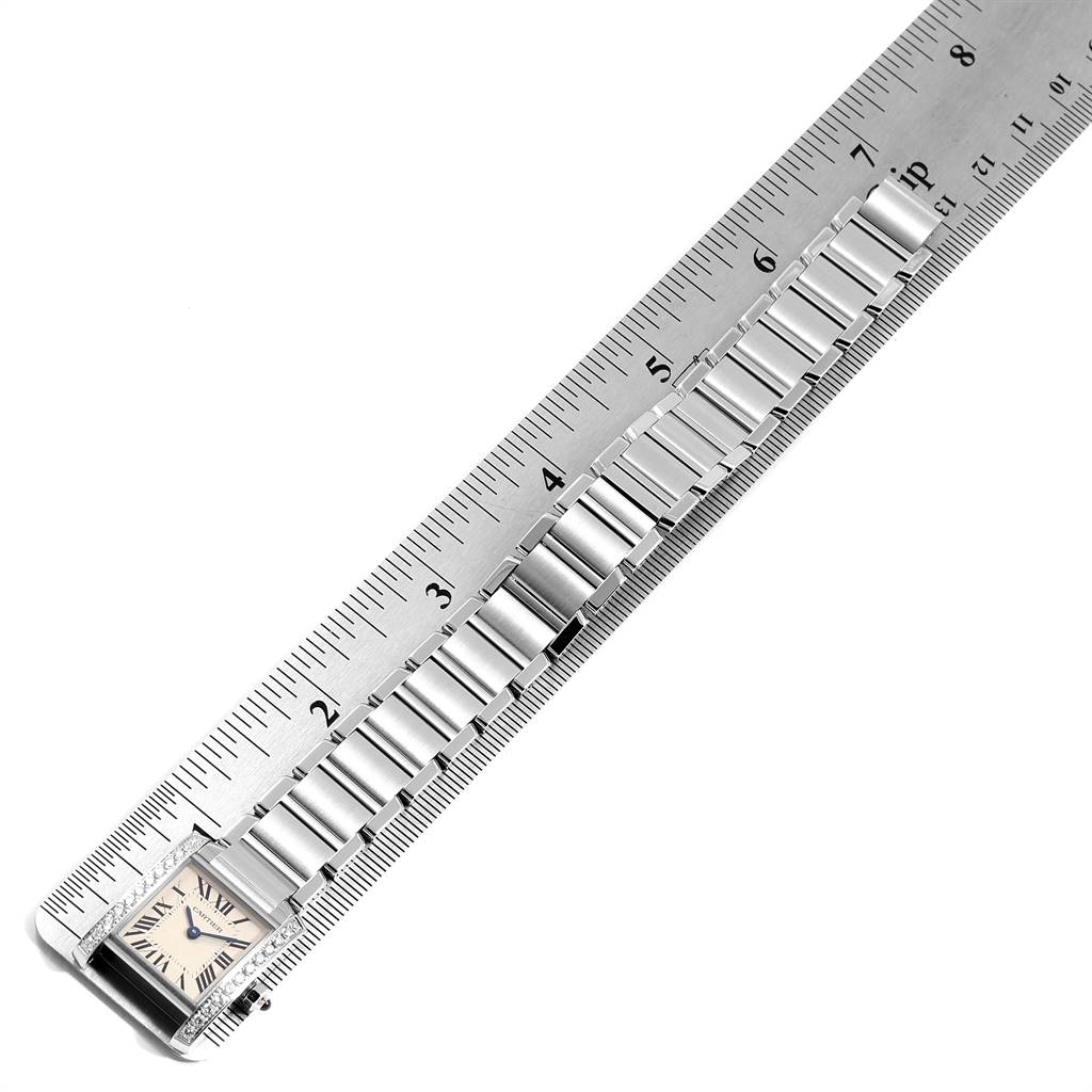 This image shows a Tank Francaise watch by Cartier horizontally measured against a ruler, displaying the watch face and bracelet links.