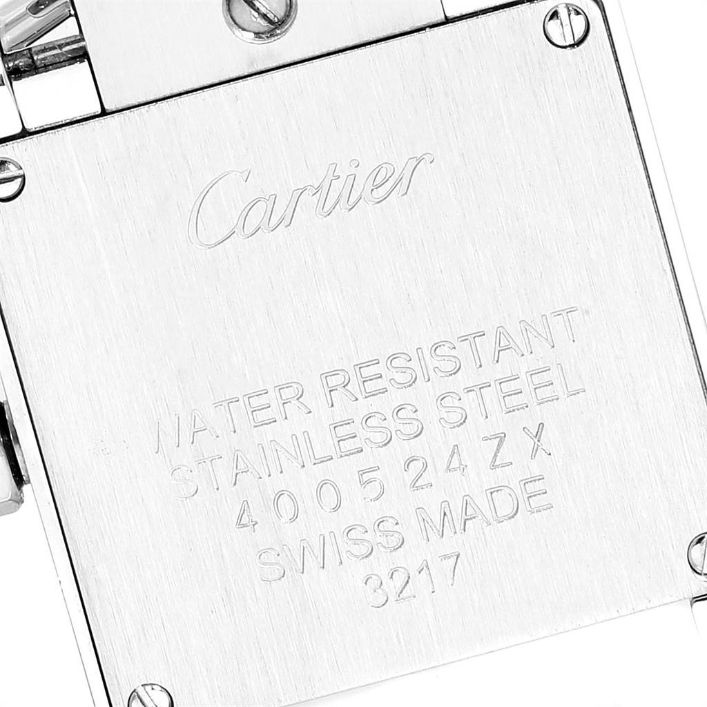 This image shows the back casing of a Cartier Tank Francaise W4TA0008 Women
s Stainless Steel Silver Dial W4TA0008 Women
s Stainless Steel Silver Dial watch, featuring engraved details and screws.