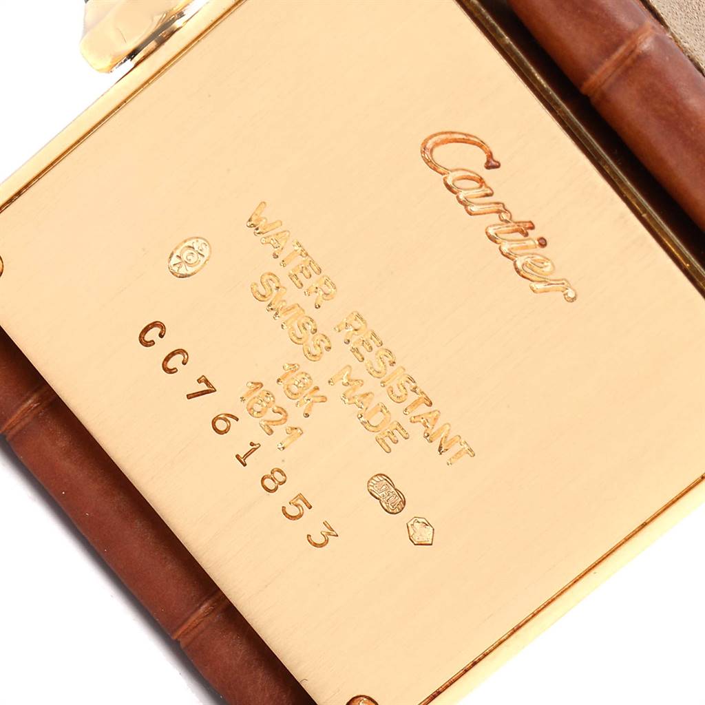 The image shows the back of the Cartier Tank Française watch, highlighting its engravings and part of its leather strap.