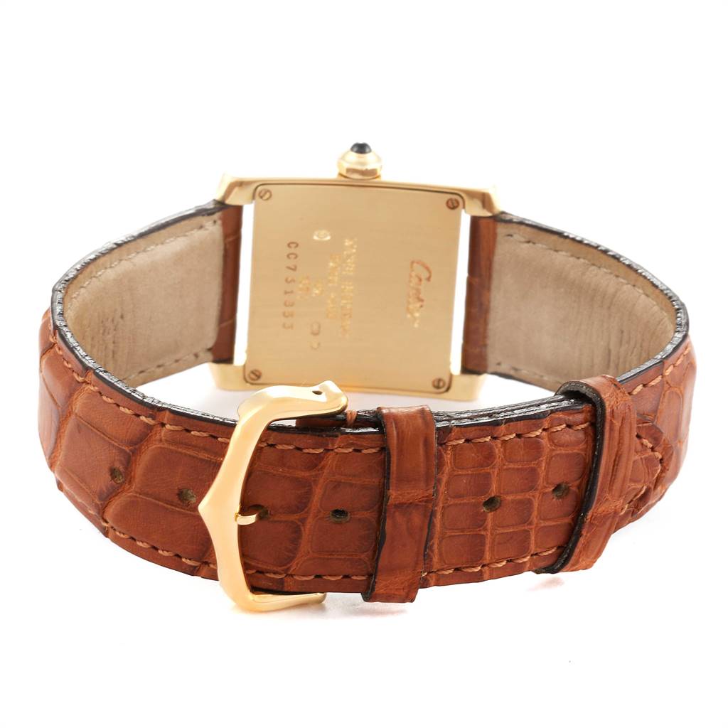 The image shows the back and band of a Tank Francaise watch by Cartier, with a brown leather strap and gold clasp.