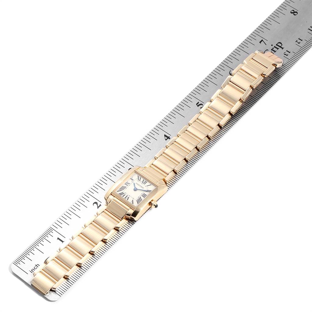 The image shows a Cartier Tank Française watch laid flat on a ruler, displaying the face and entire band.