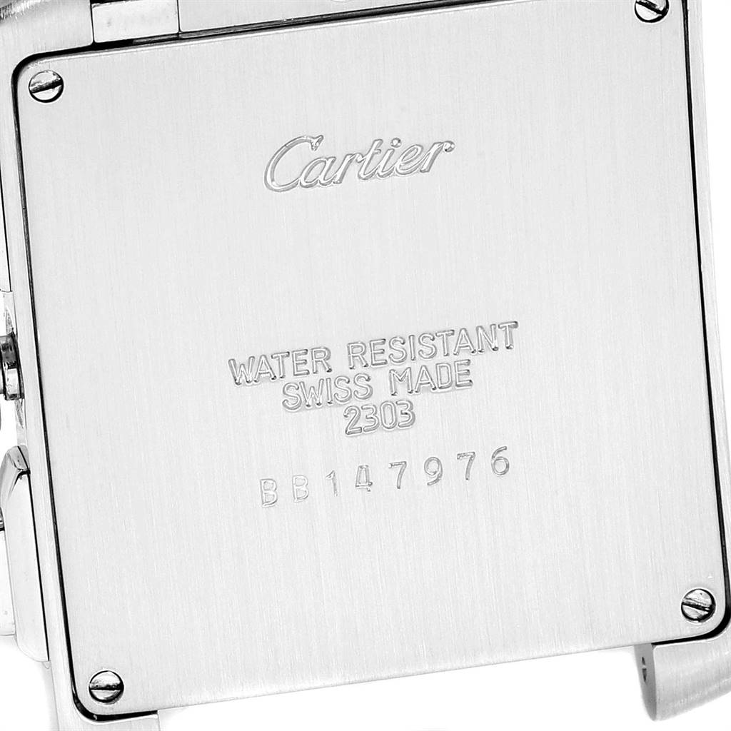 The image shows the back case of a Cartier Tank Française watch, displaying inscriptions and four screws.