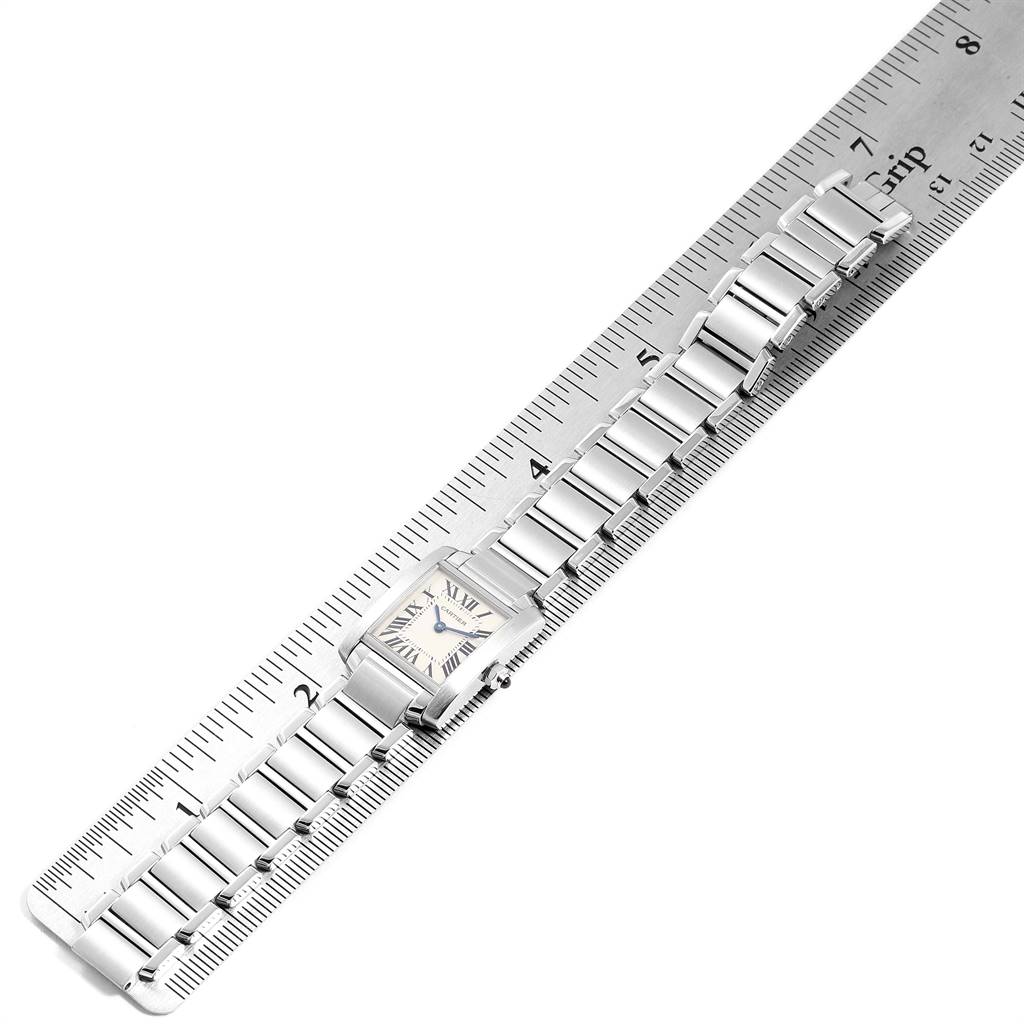 The Cartier Tank Francaise W51008Q3 Women
s Stainless Steel Silver Dial W51008Q3 Women
s Stainless Steel Silver Dial watch is shown in a top-down angle, displaying its face and metal bracelet on a ruler.