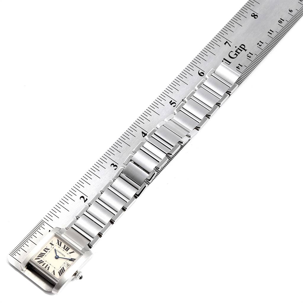The image shows a Cartier Tank Française model watch with a bracelet laid next to a ruler, displaying measurements.